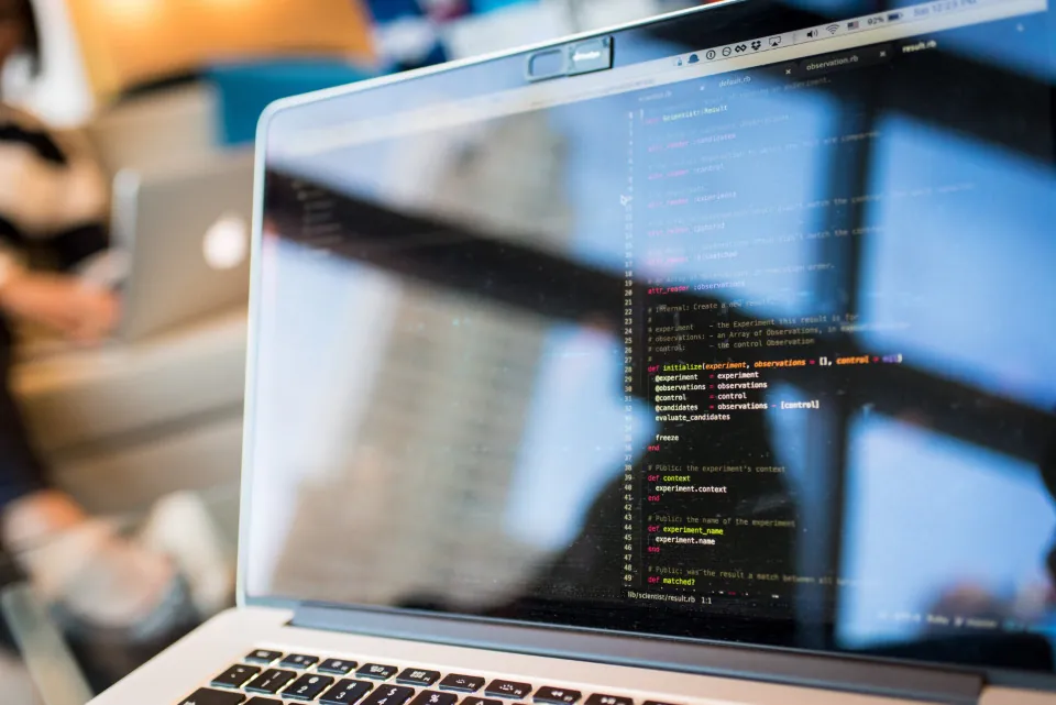 Écran d’ordinateur portable affichant du code, dans un espace de travail